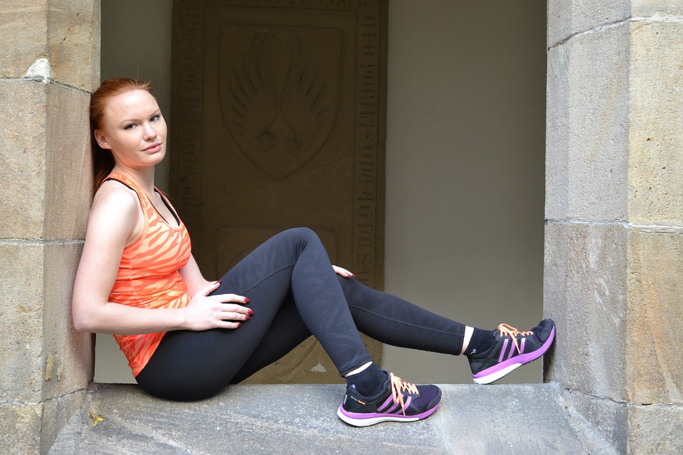 Žena ve sportovním oblečení, outfit který doplňují leginy.